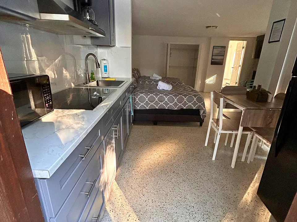 Bright kitchen with cabinets, microwave, coffee maker & essentials.
