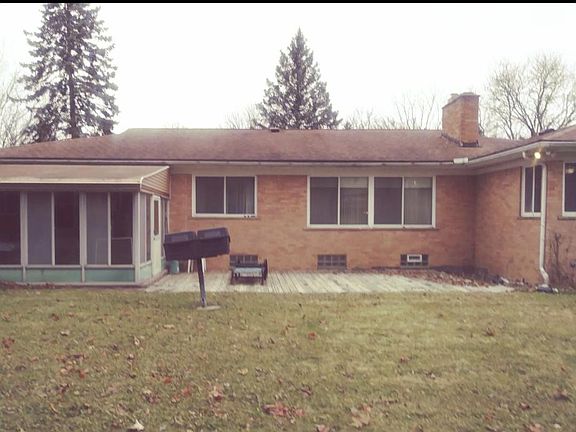 Large yard with a wooden deck and screened 3 seasons porch