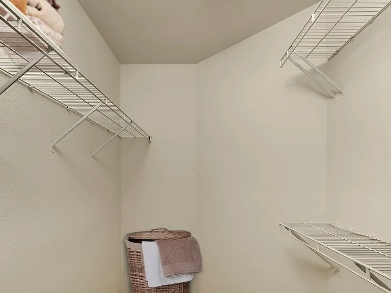 Walk-in closet with linen storage space and hanging racks