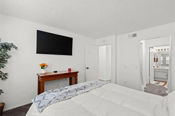 Primary bedroom with view of primary bathroom