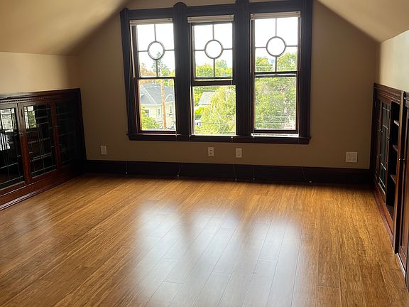 Living room with original windows looking toward Oakland with built in bookshelves with leaded glass