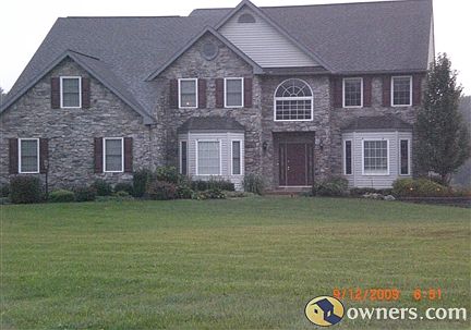 This stone front home on a 7.29 acre lot has great curb appeal
