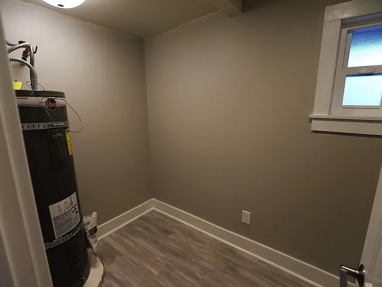 Bed 1 closet area, hot water heater and window shown.