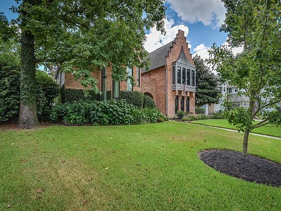 The home is surrounded by established landscaping and beautiful shade trees.