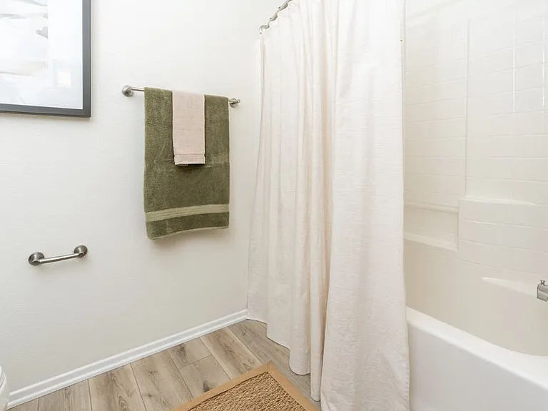 Clean Bathroom Featuring Tub-Shower Combo and Neutral Shower Curtain