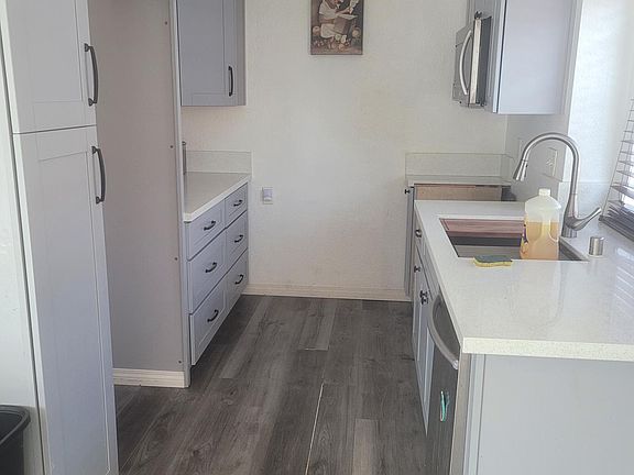 Gally style kitchen with provided dishwasher. 10inch dept stainless steel sink, with motion sensored faucet. Laminate flooring with stylish shaker cabinets and pull out drawers and spice rack.