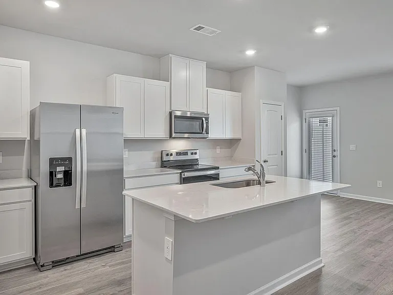The large, open kitchen has plenty of storage plus a pantry, and leads to the back patio.