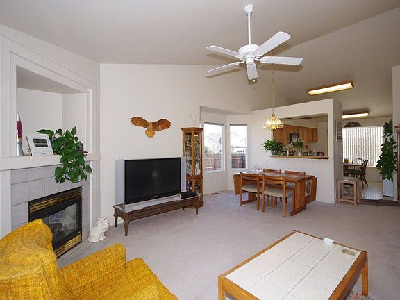 Gas log fireplace next to bay window, ceiling fan, Light and bright colors