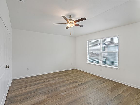 Master bedroom with a vaulted ceiling, recessed lighting, and large windows.