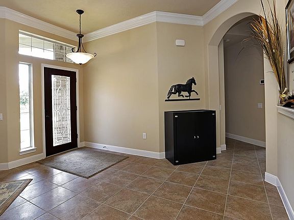 Your beautiful entry features a glass front door, crown molding, and 18" tile set on a diagonal.