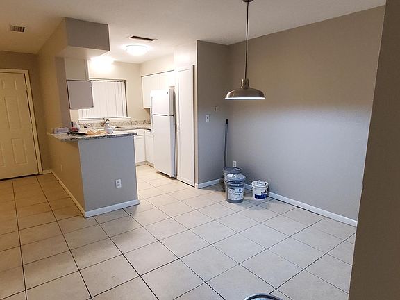 Looking through dining area (new light) to kitchen with living room and front door on left side
