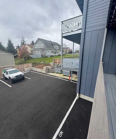view of parking and trash area