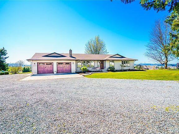 Large gravel driveway with ample parking.