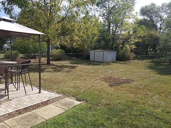 Large backyard with patio and small storage shed