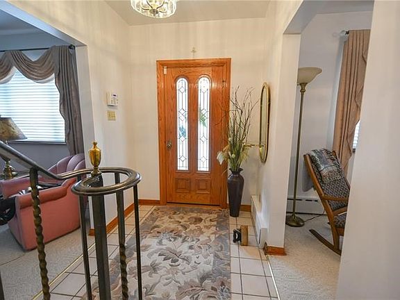 Foyer with ceramic tile flooring open to living room, dining room and kitchen