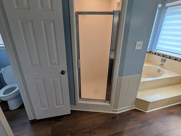 A wide-angle photo with the private toilet area, shower and garden tub visible.