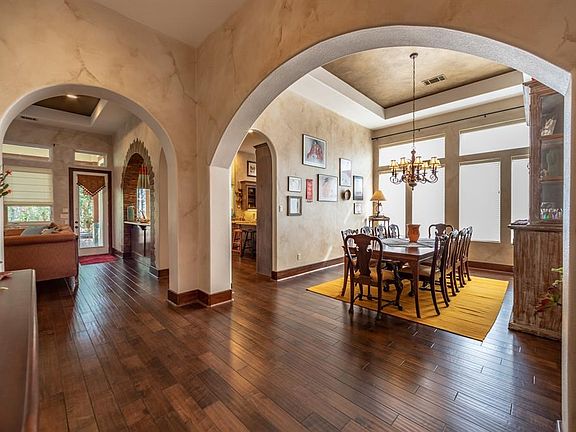 Banquet sized formal dining room with tray ceiling and chandelier.
