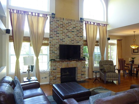 Two story Family room with wall of windows and open to Eating area, hardwood floors
