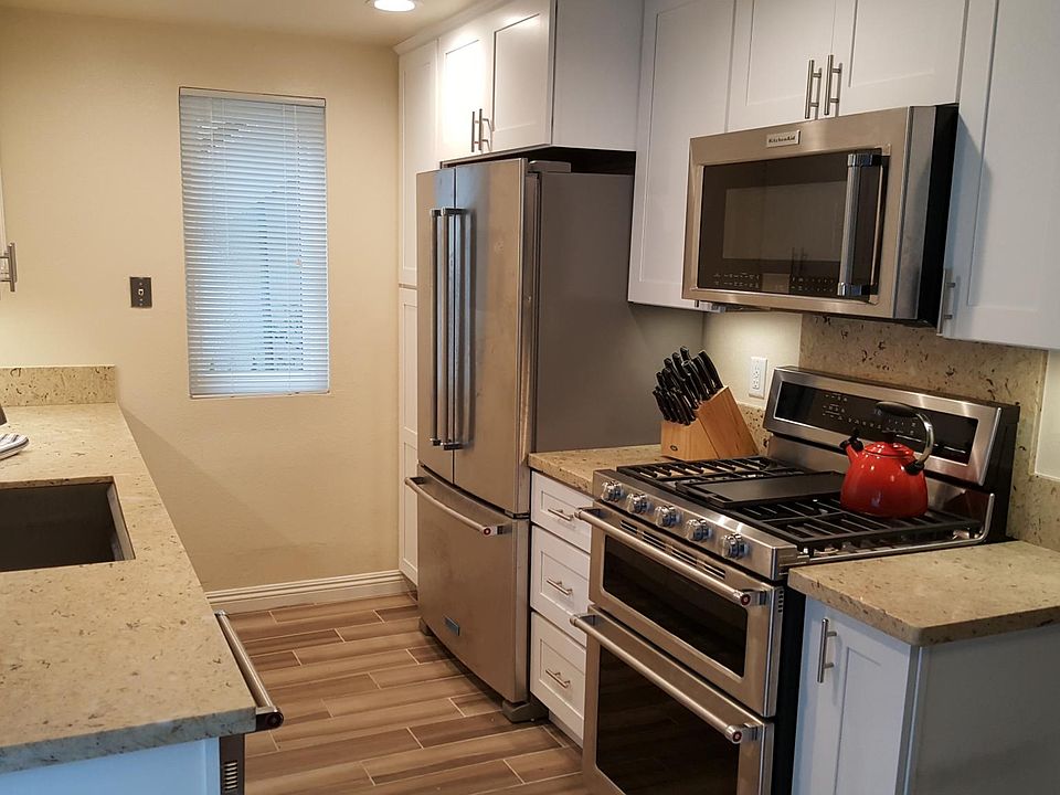 Designer kitchen with quartz countertops, custom cabinets, under cabinet lighting and Kitchen Aid appliances.