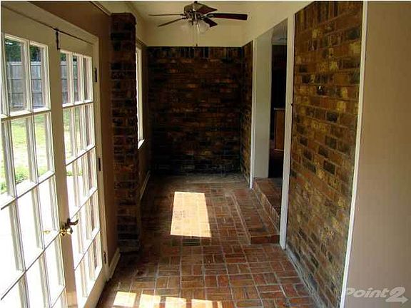 The bricked Florida room has french doors opening to the babkyard.
