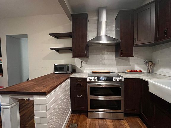 Kitchen with marble countertops and butcher block counter-heigh bar