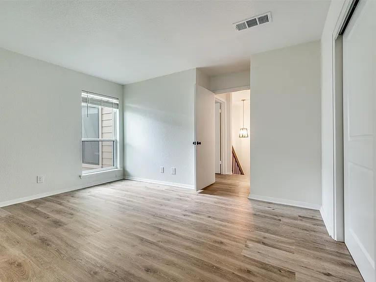 Light-filled interior space featuring wood-finish flooring, white baseboards, and neutral wall tones