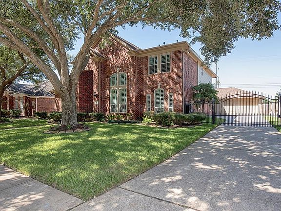 An electric wrought iron gate on the double wide driveway adds extra protection.