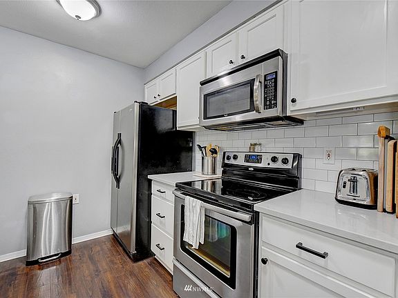 Kitchen with brand new quartz counters and tile backsplash