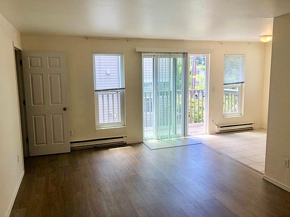 Front room with newer vinyl flooring and slider to deck. Kitchen and eating nook has tile flooring