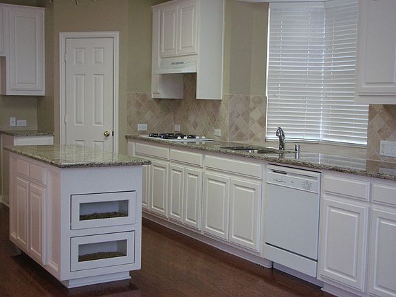 Kitchen with large island, walk in pantry and gas cooktop.