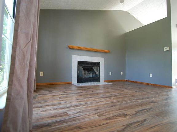 Living room with cathedral ceiling and wood burning fireplace