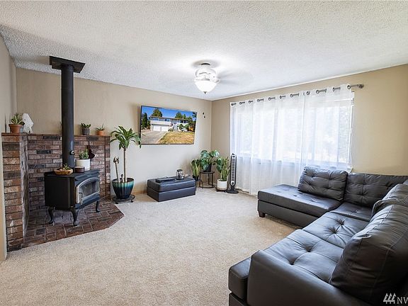 Spacious living room that can accommodate large furniture.  Cozy wood burning stove.  Television mount stays.