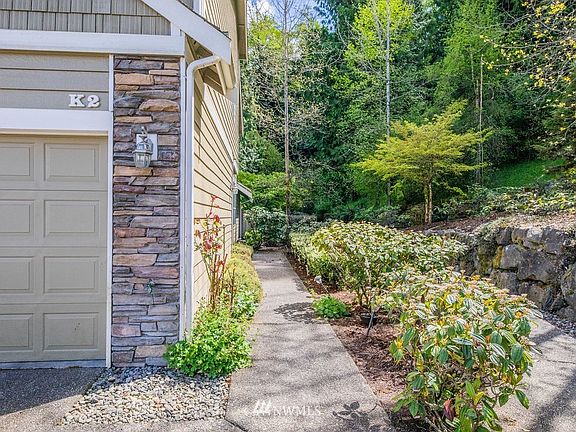 The walkway to the front door is surrounded by nature. 