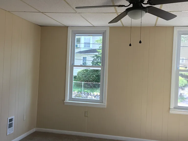 Large bedroom facing Morris St. It has 3 windows and ceiling fan.