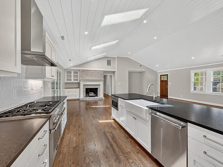 View from kitchen towards gas fireplace and family room. Front door on top right of the frame.