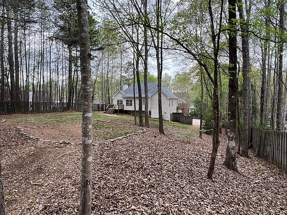 Large fenced in and partially wooded backyard