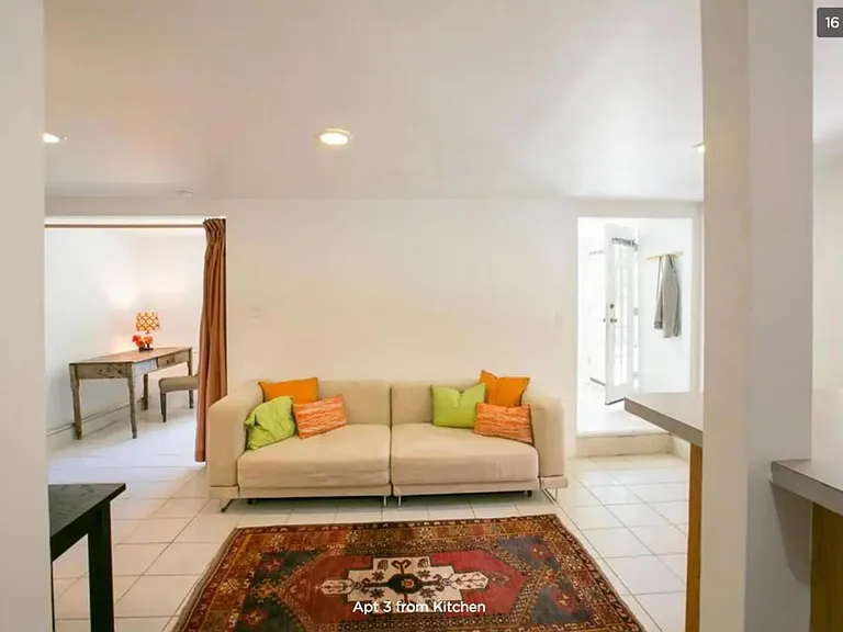View from kitchen of the main salon with view of front entrance (right), and the office/bedroom(left) both have a large mirrored closet not pictured.