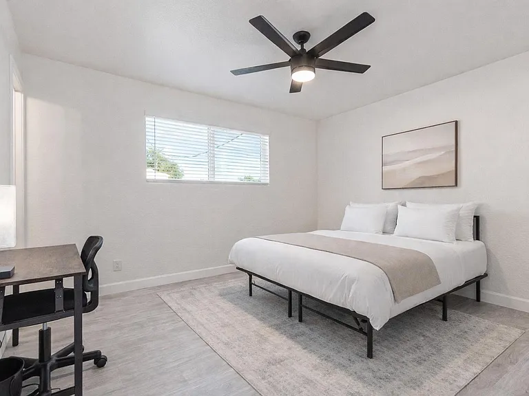 Spacious room with lots of closet space, desk and chair and ceiling fan! Bedding and rug virtually staged.