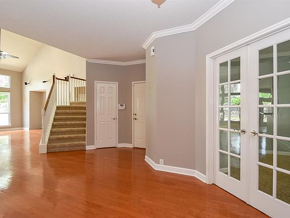 Grand entryway with hardwood floors and double glass pane doors leading into a private study