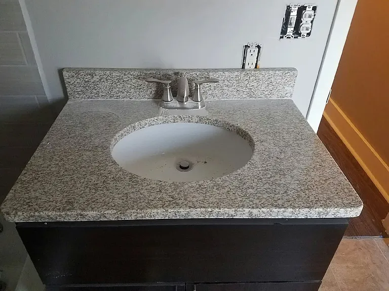 Elevate your daily routine with this elegant bathroom featuring a beautifully crafted granite countertop and sleek modern fixtures. Perfect for adding style and functionality to your space. Explore your options at LS Capital Group today.