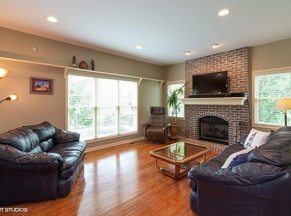 Floor to Ceiling Pella windows allows the light to shine in! Brick fireplace adds to the charm and appeal!