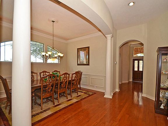 The wood floors continue from the impressive entry to the elegant formal dining area. The arches and columns lend to the dramatic feel this spacious dining room!
