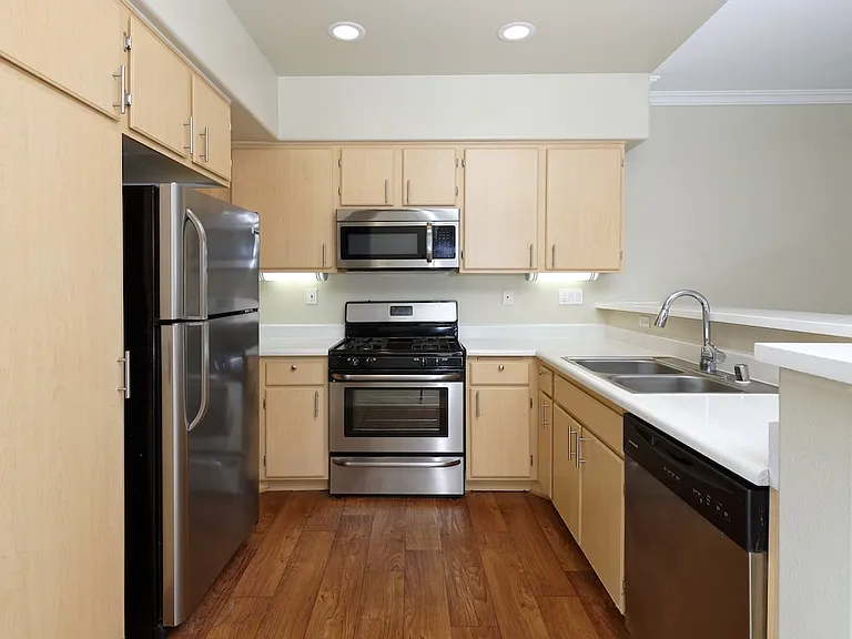 Classic Package II kitchen with stainless steel appliances, laminate countertops, oak cabinetry, and hard surface flooring