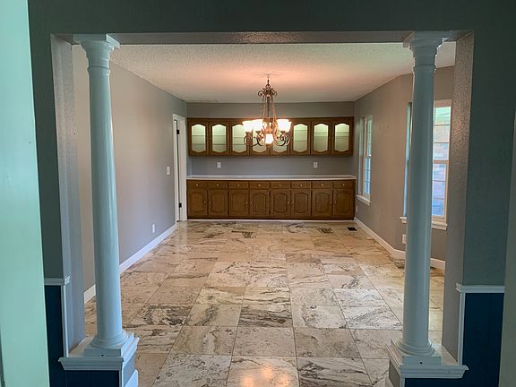 Entry opens in formal dining/ second living area. Wall of cabinets with buffet counter and lighted, glass front upper cabinets.