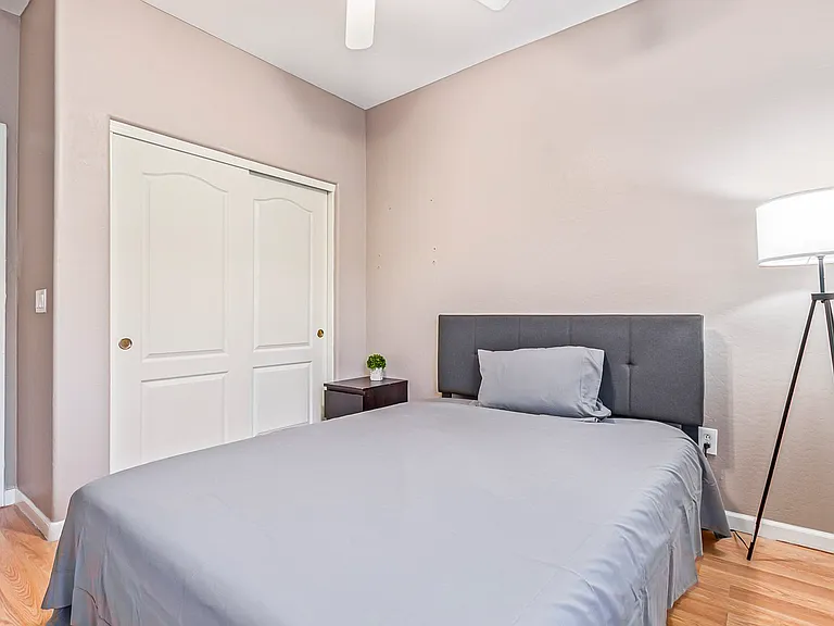 Full Size bed and closet with lamp and ceiling fan and light