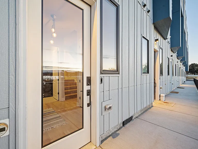 Enter through the garage or this front entrance with Eufy smart lock facing the beautiful Rocky Mountain Lake. Google Nest video doorbell that is actively recording for safety and security. Half bath and coat rack bench at entry for convenience.