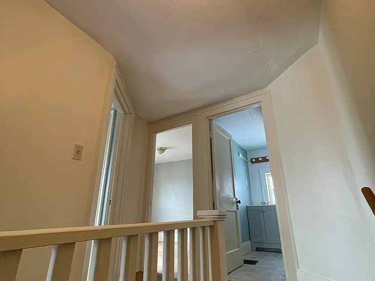 Top of stairway, leading into bathroom.