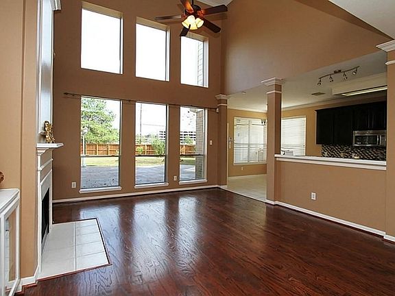 Dramatic floor to ceiling windows overlook beautiful backyard setting.