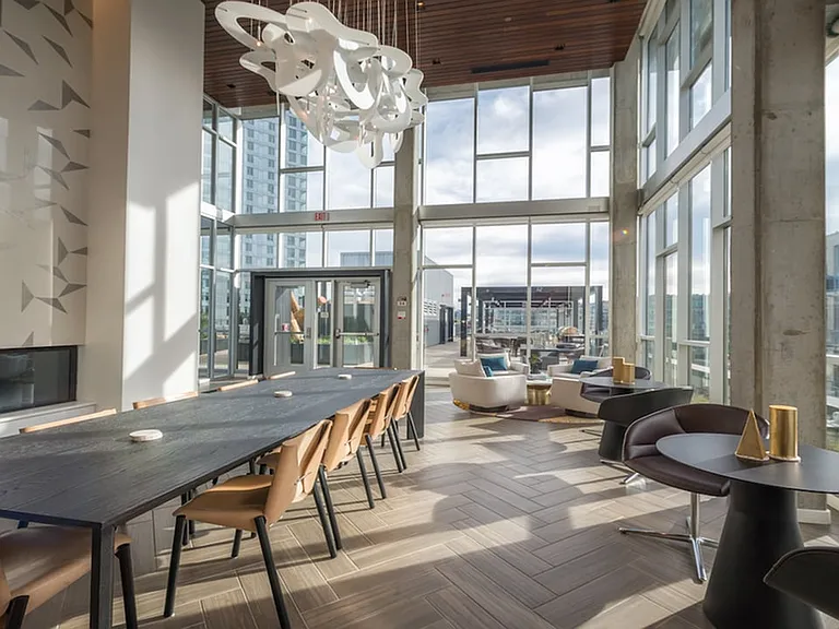 Brightly lit resident lounge with ceramic tile flooring and ample seating for work or play