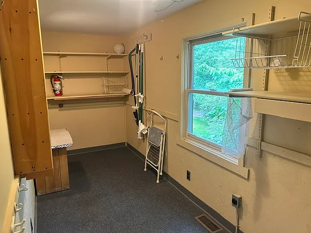 Laundry room with ample room for washer and dryer, built-in ironing board, and plenty of storage.